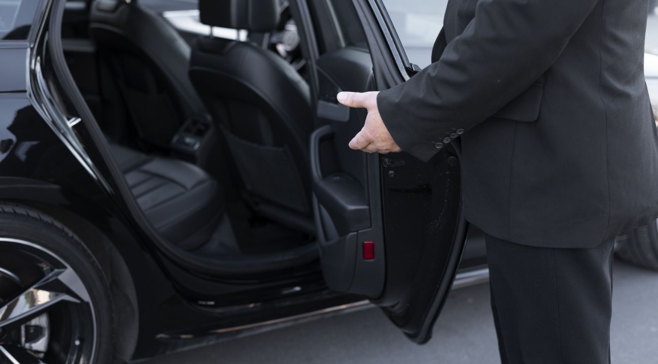 Taxi, VTC or private transfer on vacation Chauffeur opening rear door for passenger