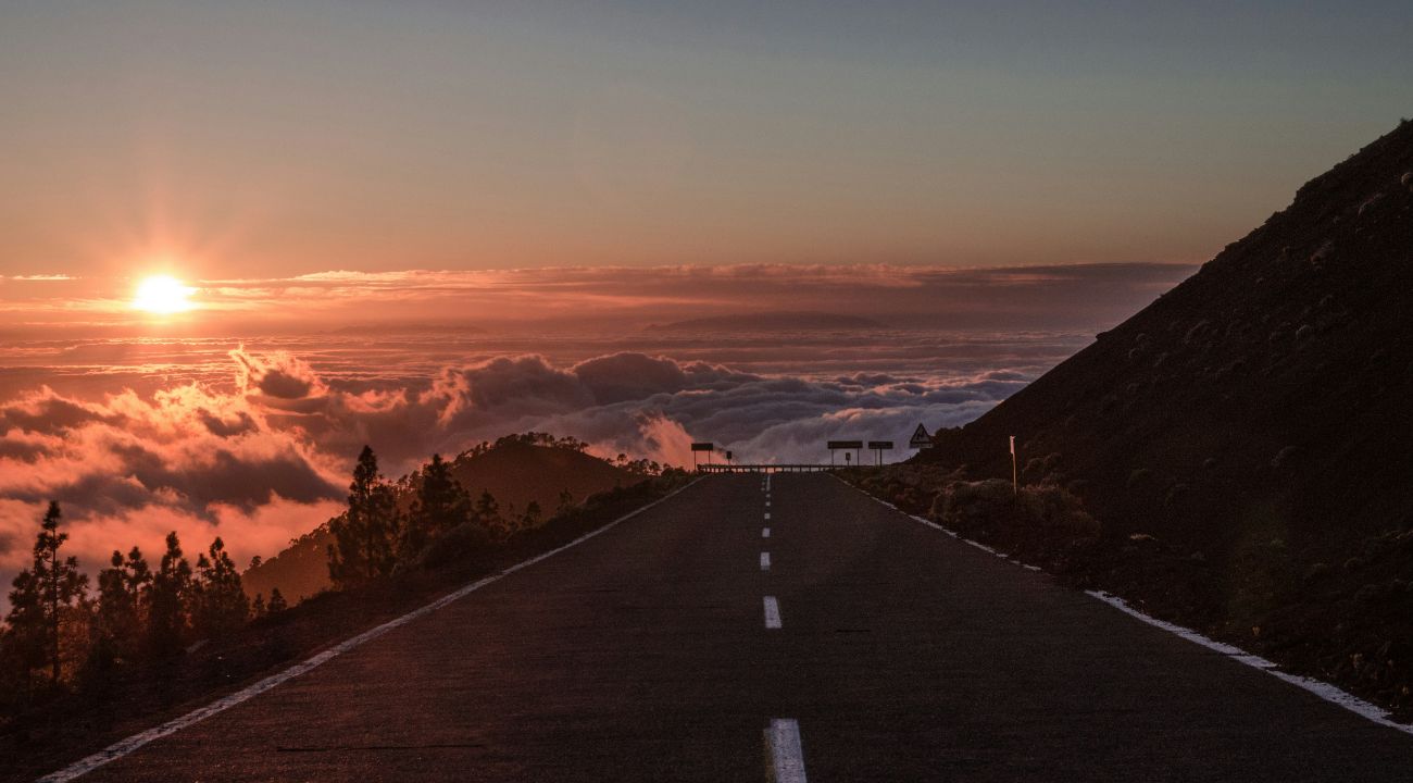 Mountain road crossing the thermal inversion at dawn, symbolizing journeys that connect destinations